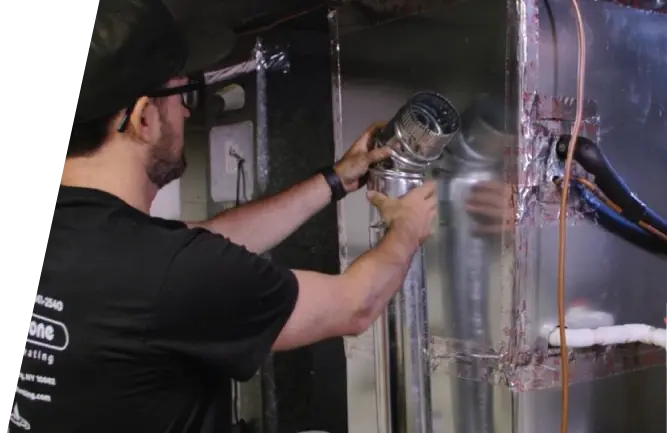HVAC technician installing vent pipe on furnace